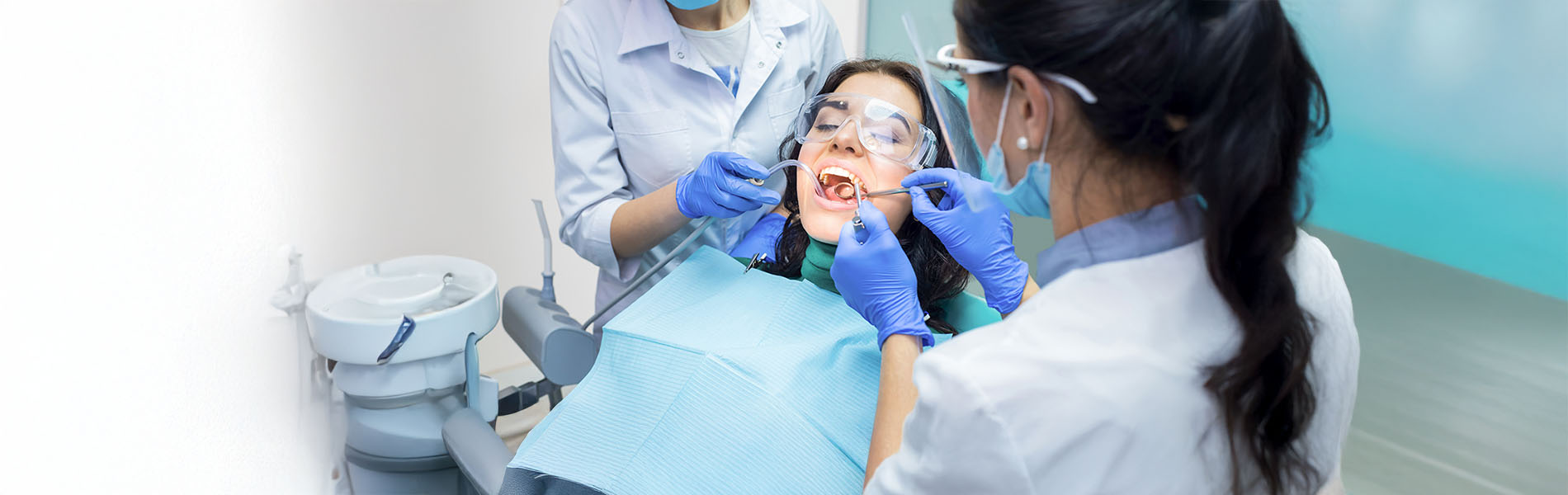 Dental hygienist performing teeth cleaning procedure on patient.