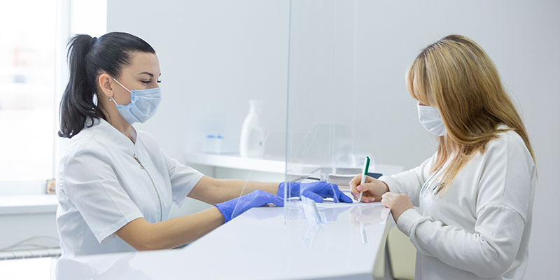 The image depicts a modern office reception area with a sleek, contemporary design featuring a wooden desk and a white countertop.